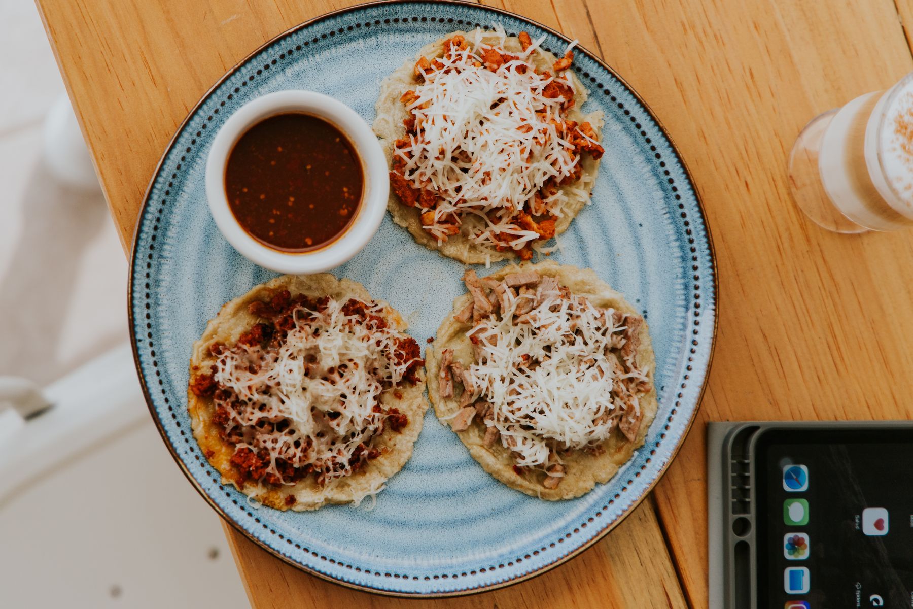A plate of traditional Mexican tostadas topped with cheese and served with salsa