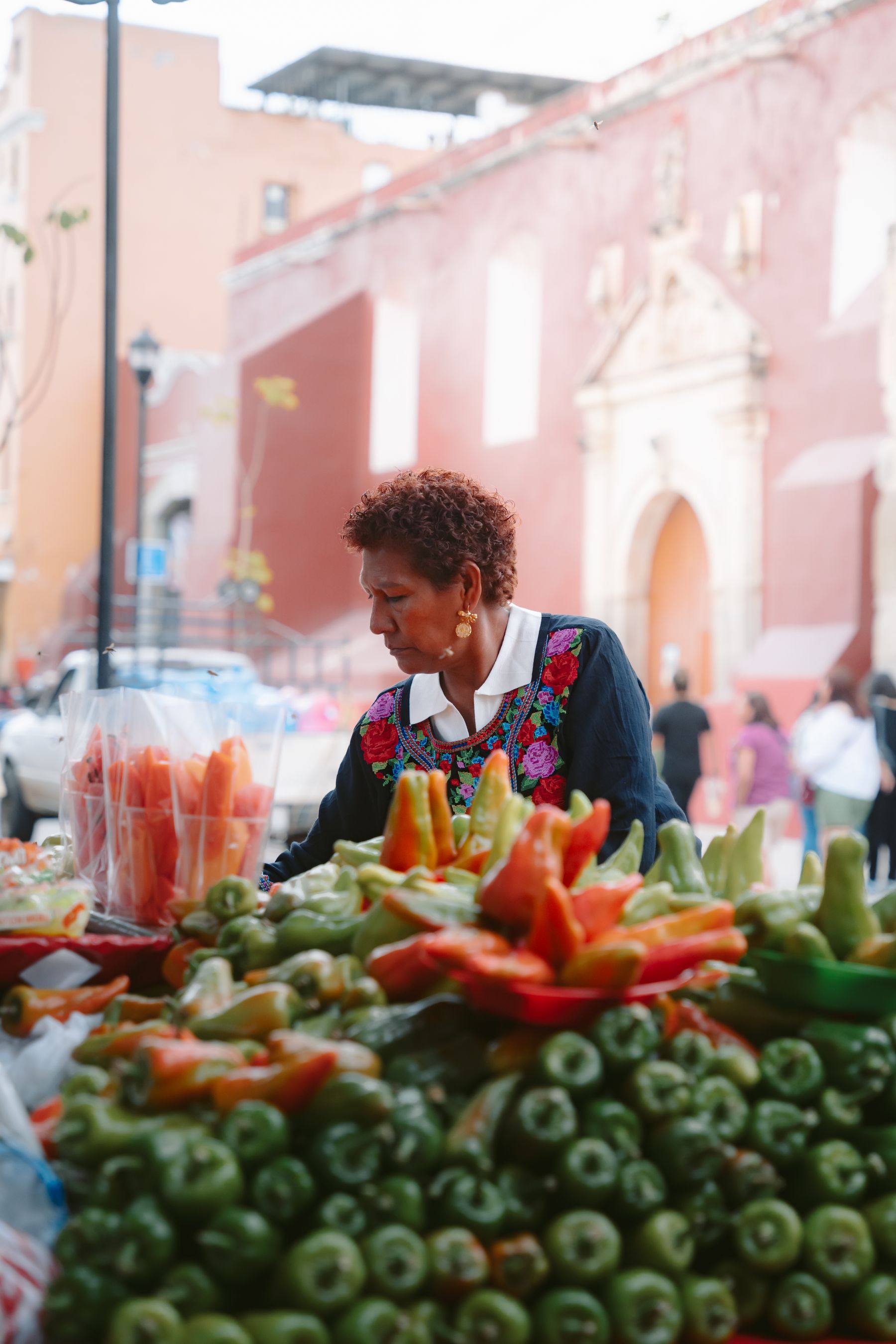 A market vendor arranging traditional vegetables in a market in Oaxaca de Juarez