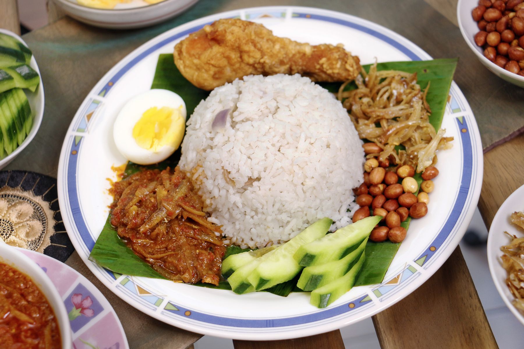 A plate of nasi lemak with rice, sambal, egg and peanuts