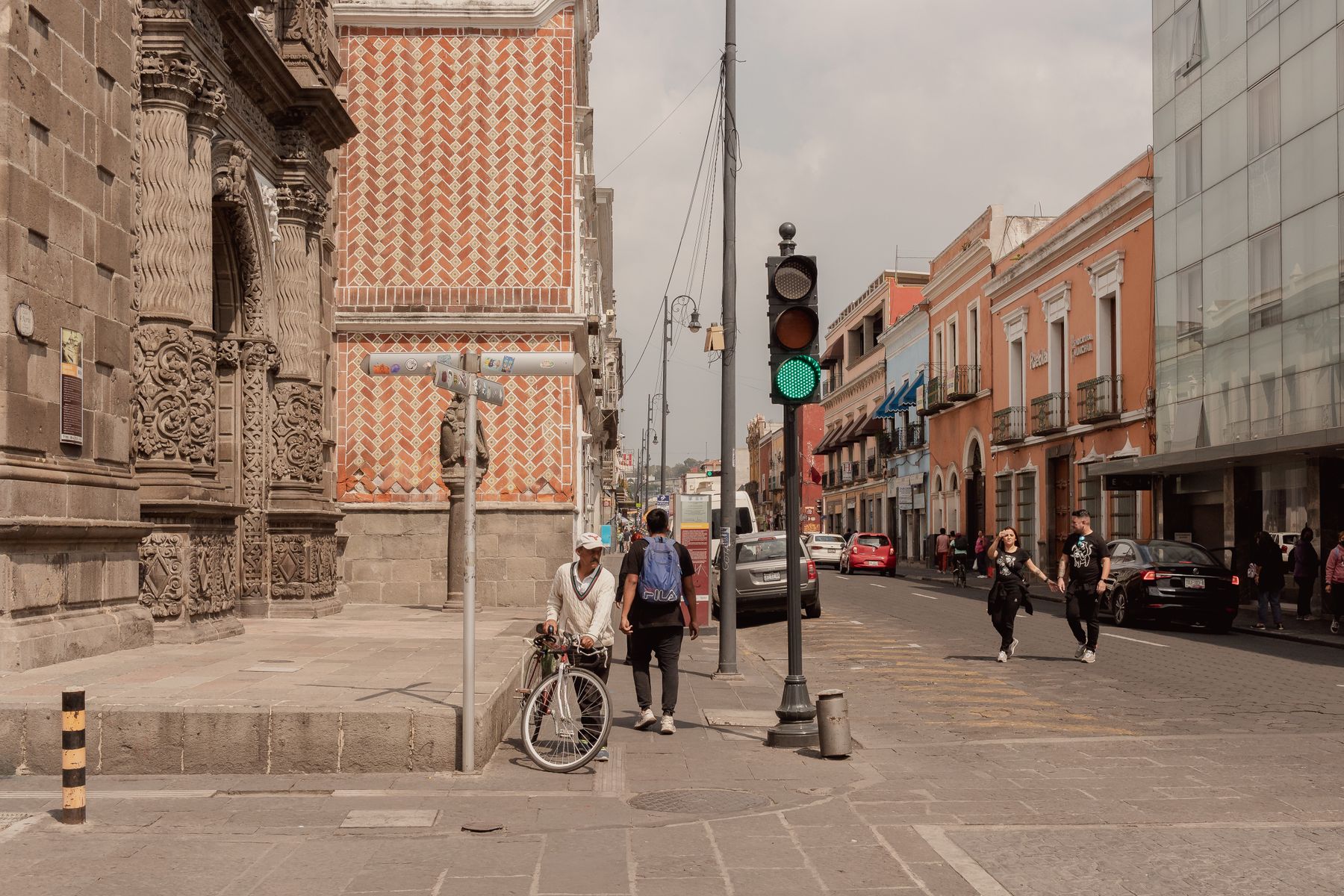 A street in Puebla, Mexico with people walking past historic colonial buildings in daylight