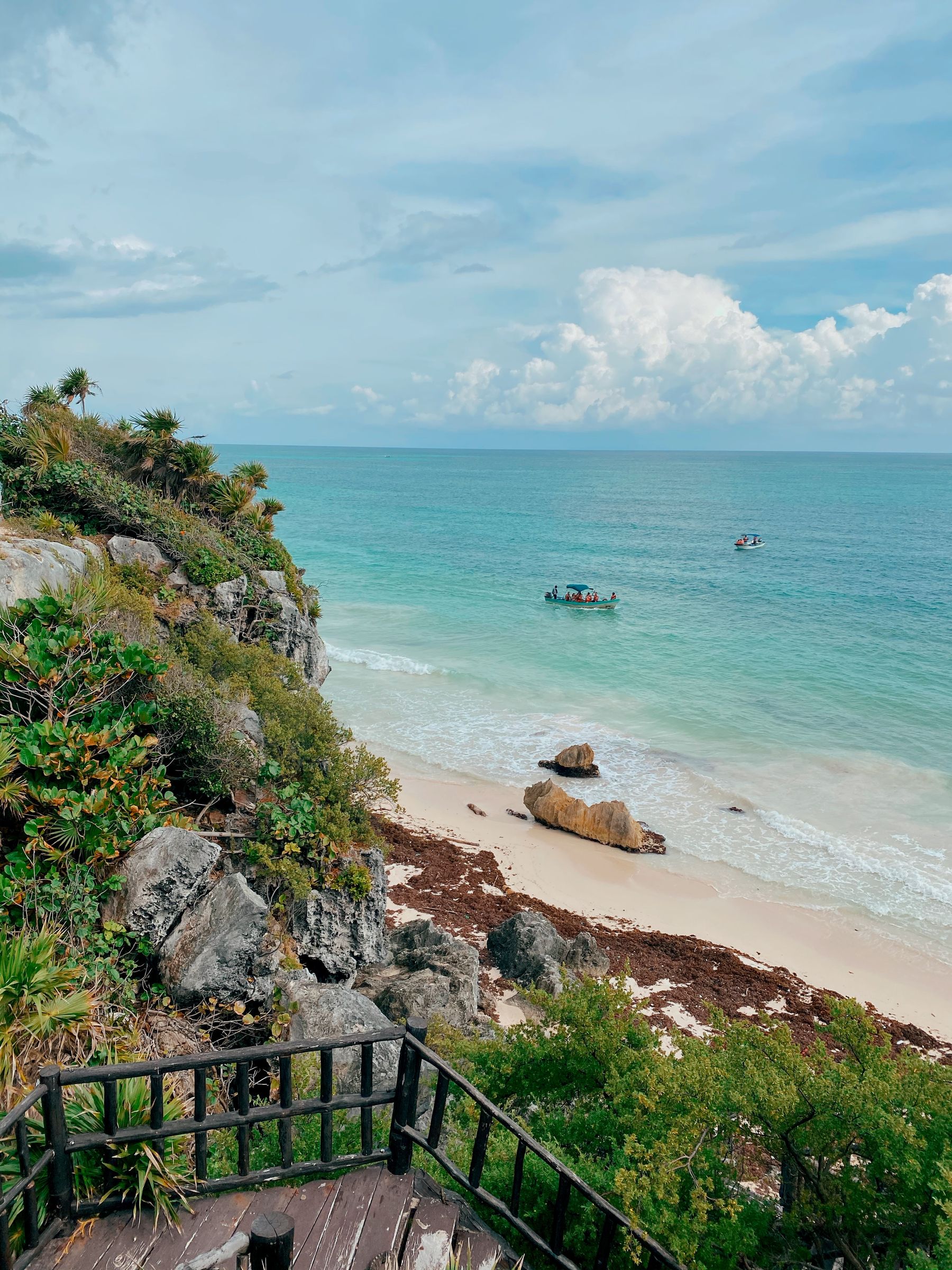 Tulum beach with turquoise water and lush greenery along the shore