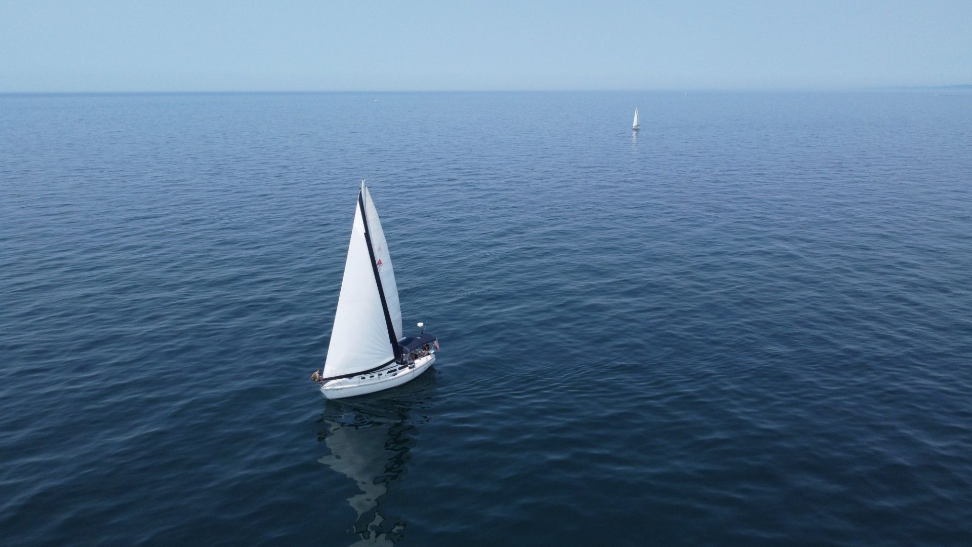 A small boat crossing open water between islands