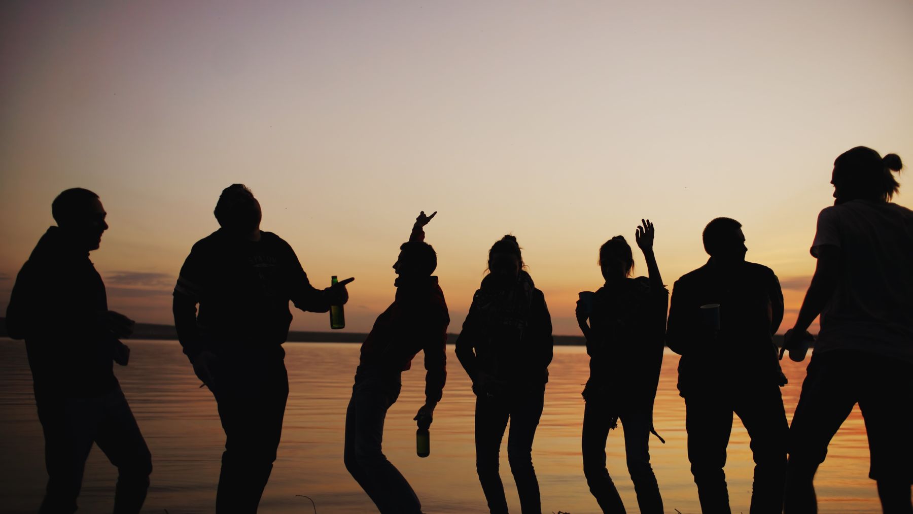 Silhouettes of people on a beach at sunset