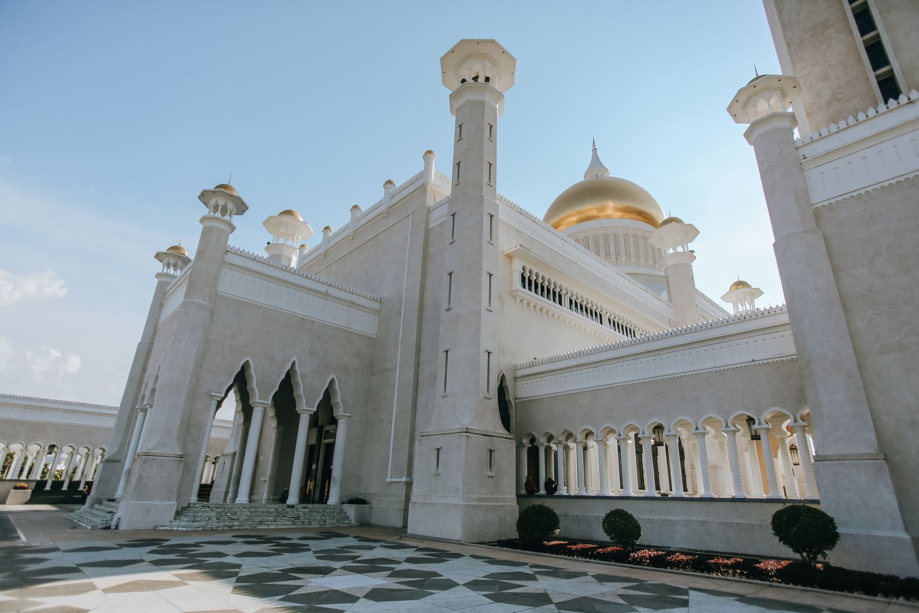 A mosque with a golden dome reflected in still water