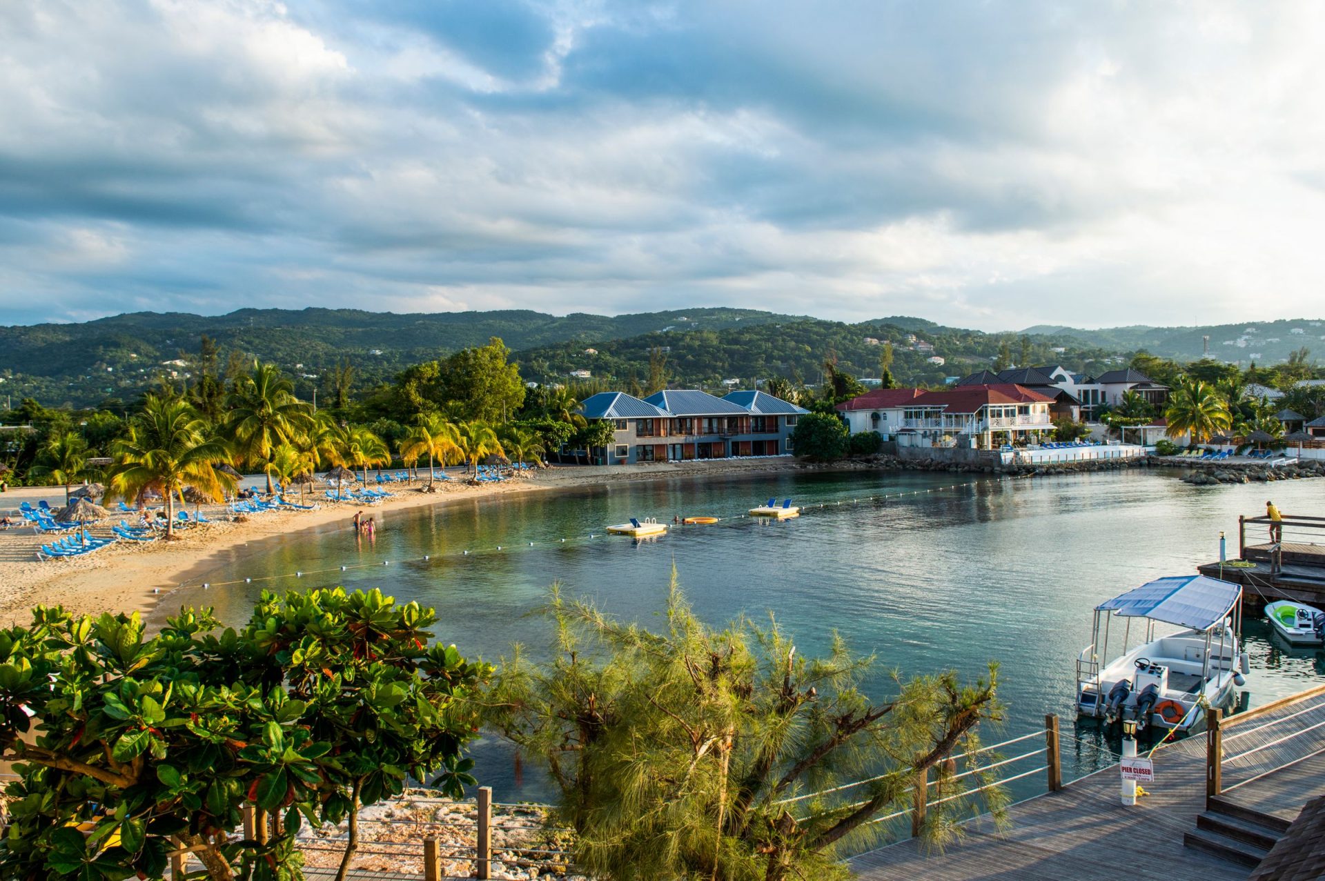 Settlement on a sandy beach below forested mountains in Jamaica