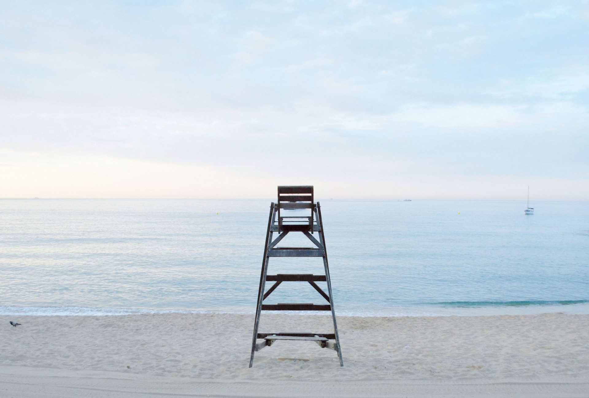 An empty beach with a lifeguard tower at first light