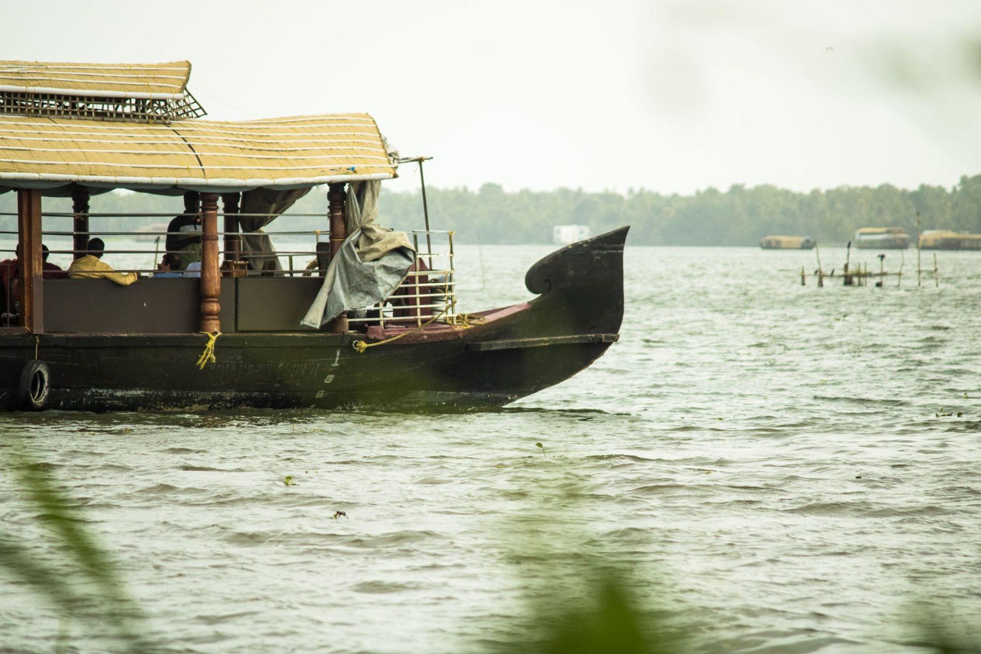 A wooden boat on calm water beside a village