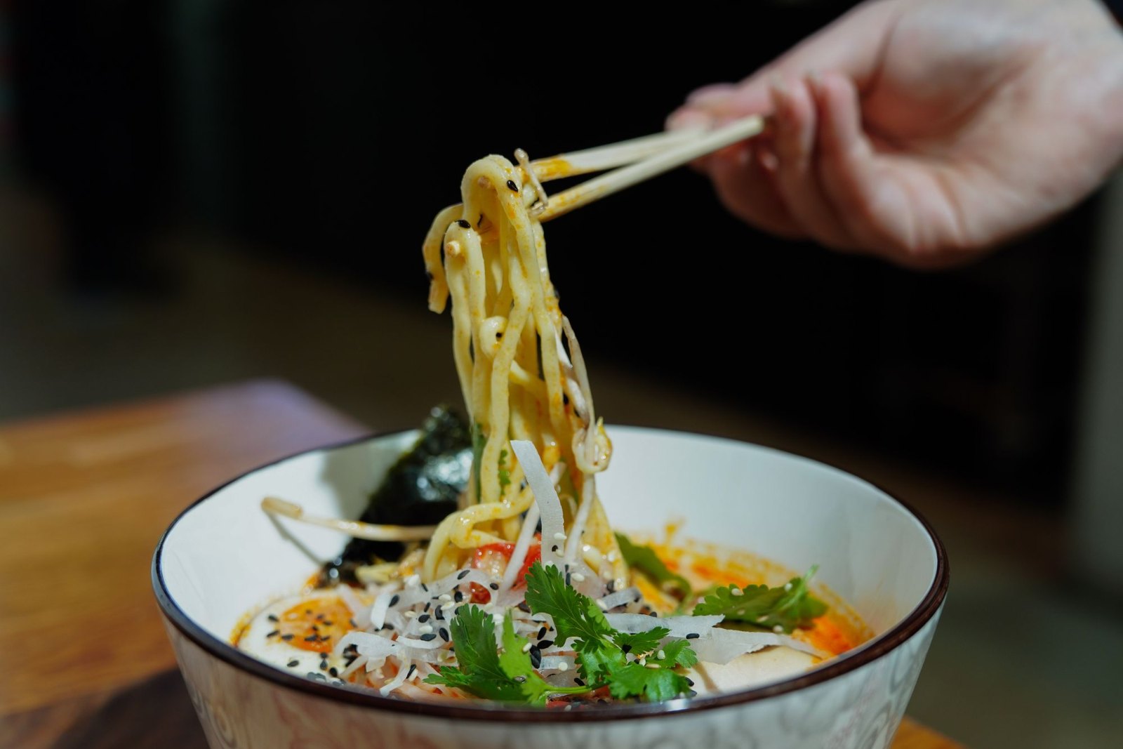 A bowl of noodle soup at a pavement table